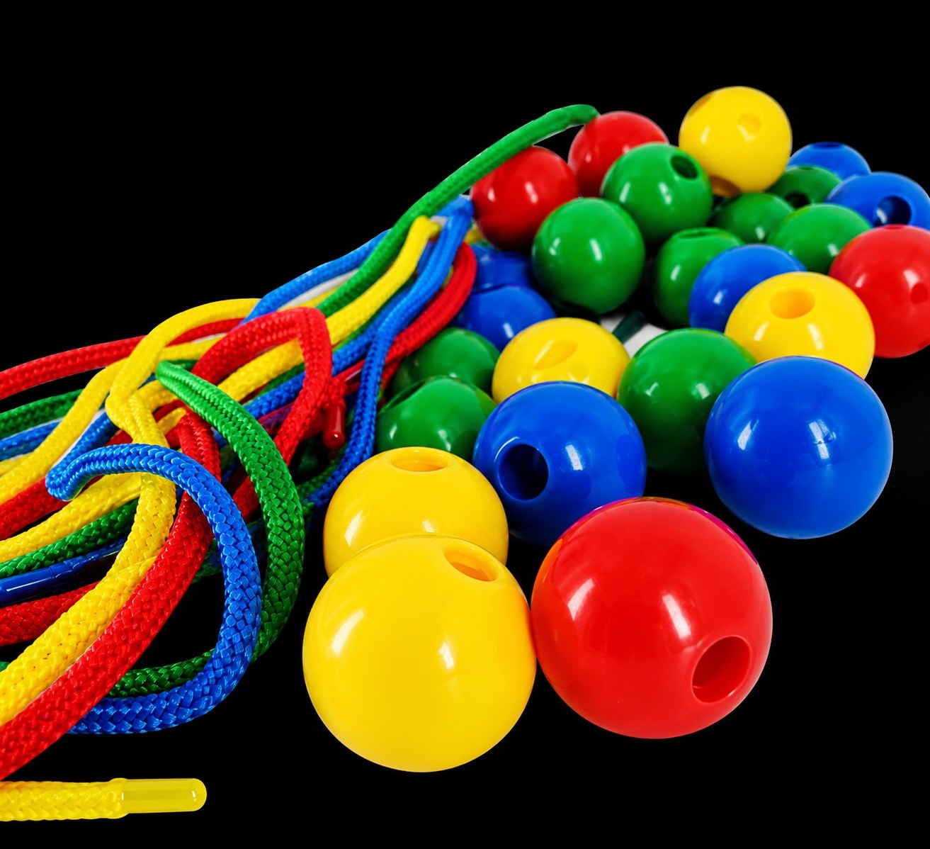 Colorful jump rope with multicolored plastic beads on a black background