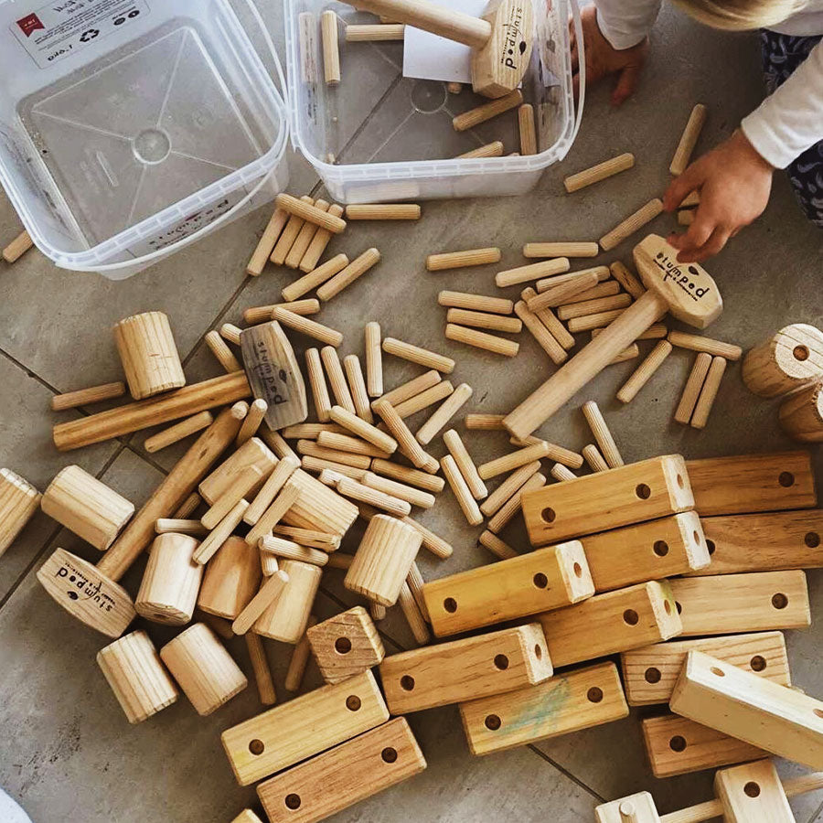 Wooden building blocks with 'pedding' branding on a concrete floor.